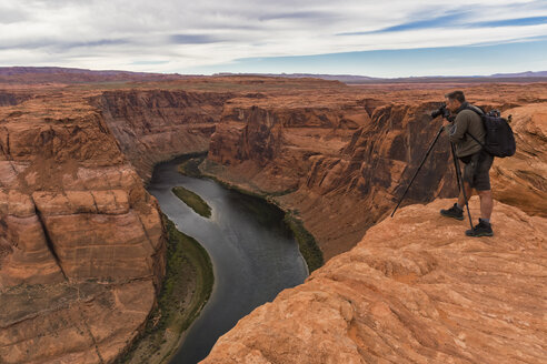 USA, Arizona, Page, Colorado River, Glen Canyon National Recreation Area, man taking picture at Horseshoe Bend - FOF09041
