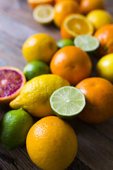 Sliced and whole limes, oranges and lemons on wood - GIOF02237