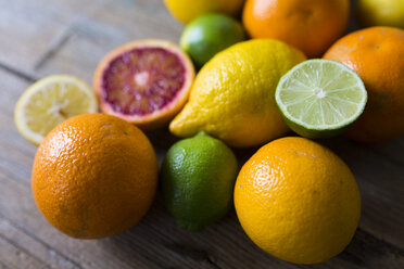 Sliced and whole limes, oranges and lemons on wood - GIOF02239