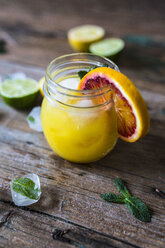 Glass of orange juice, slice of blood orange, mint leaves and ice cubes - GIOF02244