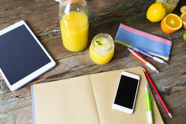 Glass of orange juice, notepad, pencils, tablet and cell phone - GIOF02253