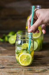 Ein Glas Wasser mit Zitrone, Limette, Minzblättern und Eiswürfeln - GIOF02269