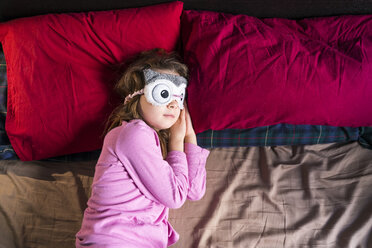 Mädchen mit Schlafmaske auf dem Bett liegend - XCF00144