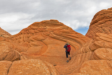 USA, Arizona, Page, Paria Canyon, Vermillion Cliffs Wilderness, Coyote Buttes, red stone pyramids and buttes, tourist taking a picture - FOF09062