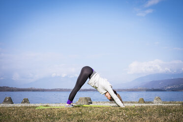 Frau übt Yoga an einem See - SIPF01460