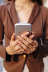 Hands of businesswoman holding cell phone, close-up - BOYF00726