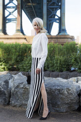 USA, Brooklyn, Dumbo, stilvolle reife Frau steht vor der Manhattan Bridge - GIOF02278