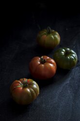 Vier Tomaten auf schwarzem Holz - YFF00658