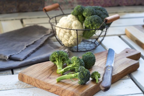 Brokkoliröschen und Küchenmesser auf Holzbrett, lizenzfreies Stockfoto