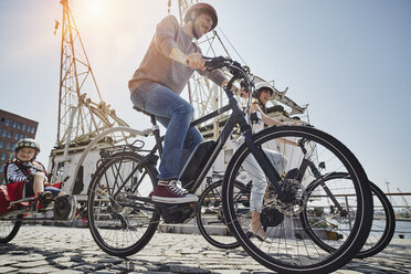 Deutschland, Hamburg, Familie fährt E-Bikes am Hafen - RORF00678