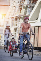 Deutschland, Hamburg, Familie fährt E-Bikes am Hafen - RORF00696