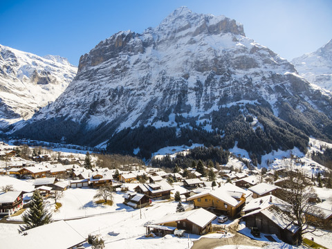 Schweiz, Kanton Bern, Grindelwald, Stadtbild im Winter bei Sonnenaufgang mit Mittelhorn, lizenzfreies Stockfoto
