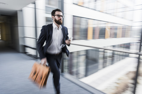 Geschäftsmann läuft im Korridor eines Bürogebäudes, lizenzfreies Stockfoto