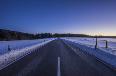 Germany, Saxony-Anhalt, Tanne, road at winter evening - PVCF01037