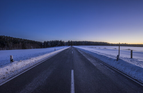 Deutschland, Sachsen-Anhalt, Tanne, Straße am Winterabend - PVCF01037