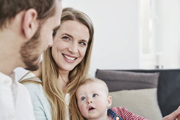 Lächelnde Mutter mit Vater und Tochter zu Hause - FMKF03586