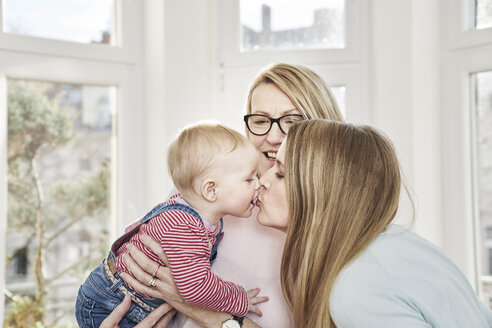 Kleines Mädchen wird von der Großmutter gehalten und küsst die Mutter - FMKF03608