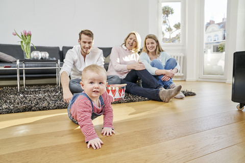Glückliche Familie mit kleinem Mädchen im Wohnzimmer, lizenzfreies Stockfoto
