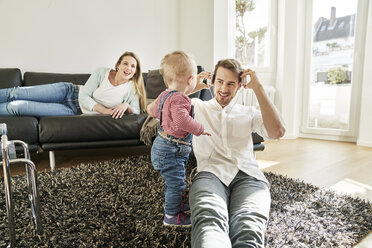 Eltern mit kleinem Mädchen im Wohnzimmer - FMKF03621