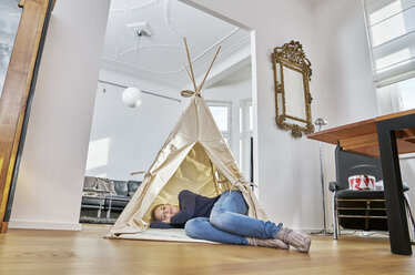 Frau liegt in einem Tipi auf dem Boden - FMKF03635