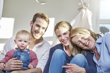 Porträt einer glücklichen Familie mit einem kleinen Mädchen zu Hause - FMKF03652