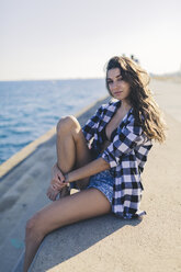 Young woman sitting at the sea - GIOF02358