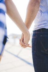 Young couple holding hands, rear view - GIOF02372