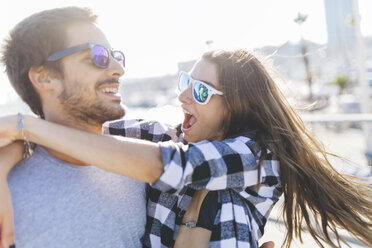 Happy young couple walking at the harbour - GIOF02376