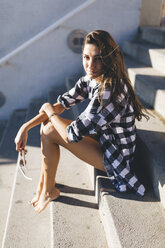 Young woan wearing shirt, sitting on stairs - GIOF02388