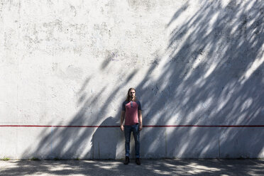 Man standing in front of concrete wall - GIOF02420