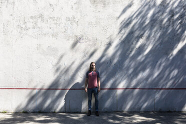 Mann steht vor einer Betonmauer - GIOF02420