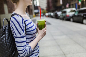 USA, New York City, Frau hält einen Smoothie in Manhattan - GIOF02438