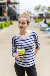 USA, New York City, confident woman drinking a smoothie in Manhattan - GIOF02449