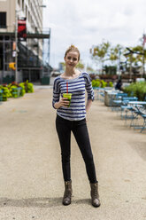 USA, New York City, Porträt einer selbstbewussten Frau mit einem Smoothie in Manhattan - GIOF02450