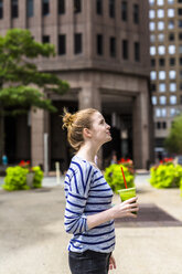 USA, New York City, woman with a smoothie in Manhattan - GIOF02451