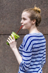 Young woman drinking a smoothie outdoors - GIOF02455