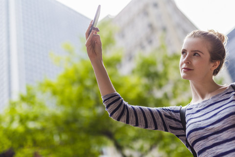 USA, New York City, Frau macht Selfie in Manhattan, lizenzfreies Stockfoto