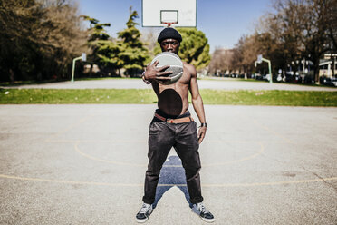 Portrait of barechested basketball player on court - GIOF02470