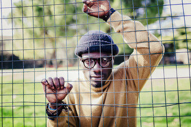 Portrait of a cool young man behind a metal net - GIOF02477
