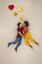 Glückliches Paar, das sich mit Emojis über dem Kopf verliebt - BAEF01251