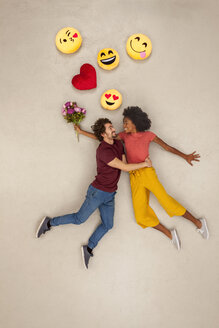 Glückliches Paar, das sich mit Emojis über dem Kopf verliebt - BAEF01252