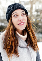Young woman outdoors in winter looking up - MGOF03089