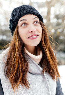 Junge Frau im Freien im Winter mit Blick nach oben - MGOF03089