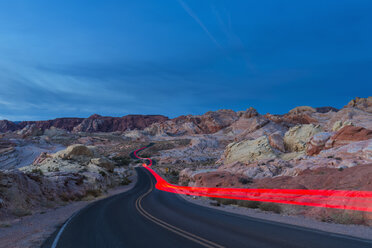 USA, Nevada, Valley of Fire State Park, Sandstein und Kalksteinfelsen, Lichtspuren eines Autos auf einer Panoramastraße in der Dämmerung - FOF09088