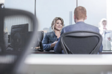 Woman and man talking at desk in office - ZEF13182