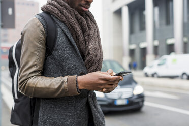 Man wearing autumn fashion text messaging - MAUF00985