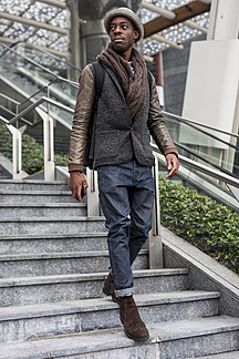 Stylish man wearing autumn fashion walking down stairs stock photo