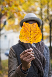 Männliche Hand hält Herbstblatt - MAUF01017