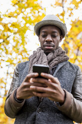 Portrait of stylish man looking at cell phone - MAUF01020