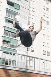 Junger Mann beim Parkour in der Stadt springt in die Luft - SKCF00271